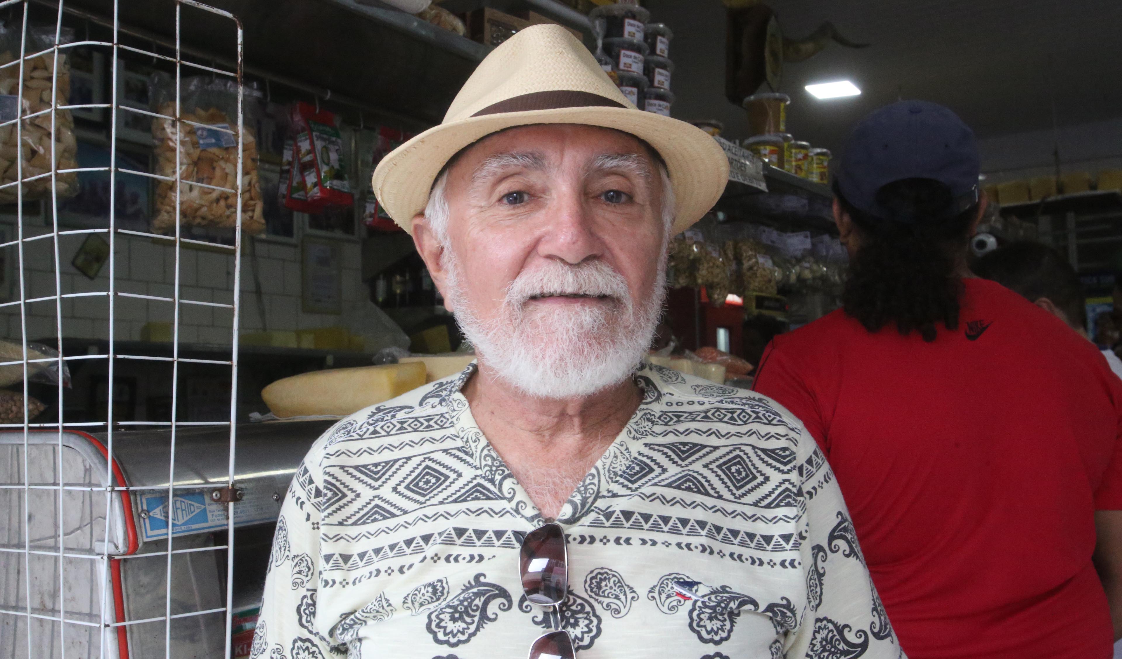 senhor idoso de chapéu e barba sorrindo para a foto